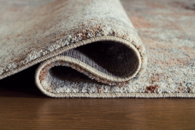 Close-up of Ashley Furniture Jadenburg Rug with detailed woven pattern and neutral tones, showcasing the textured surface.
