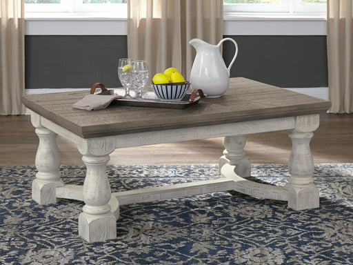 Ashley Furniture Havalance coffee table, stylish cocktail table with a sleek wooden finish, shown in a modern living room setting.