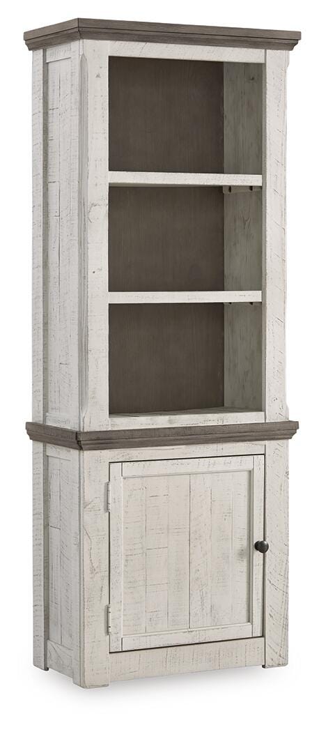 Ashley Furniture Havalance left pier cabinet with closed doors, dark wood finish, and decorative hardware in an angled view.